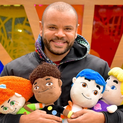 Luke Carroll holding soft toys of ELSA characters.